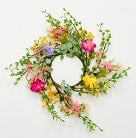 Pillar candle ring with spring flowers and green leaves